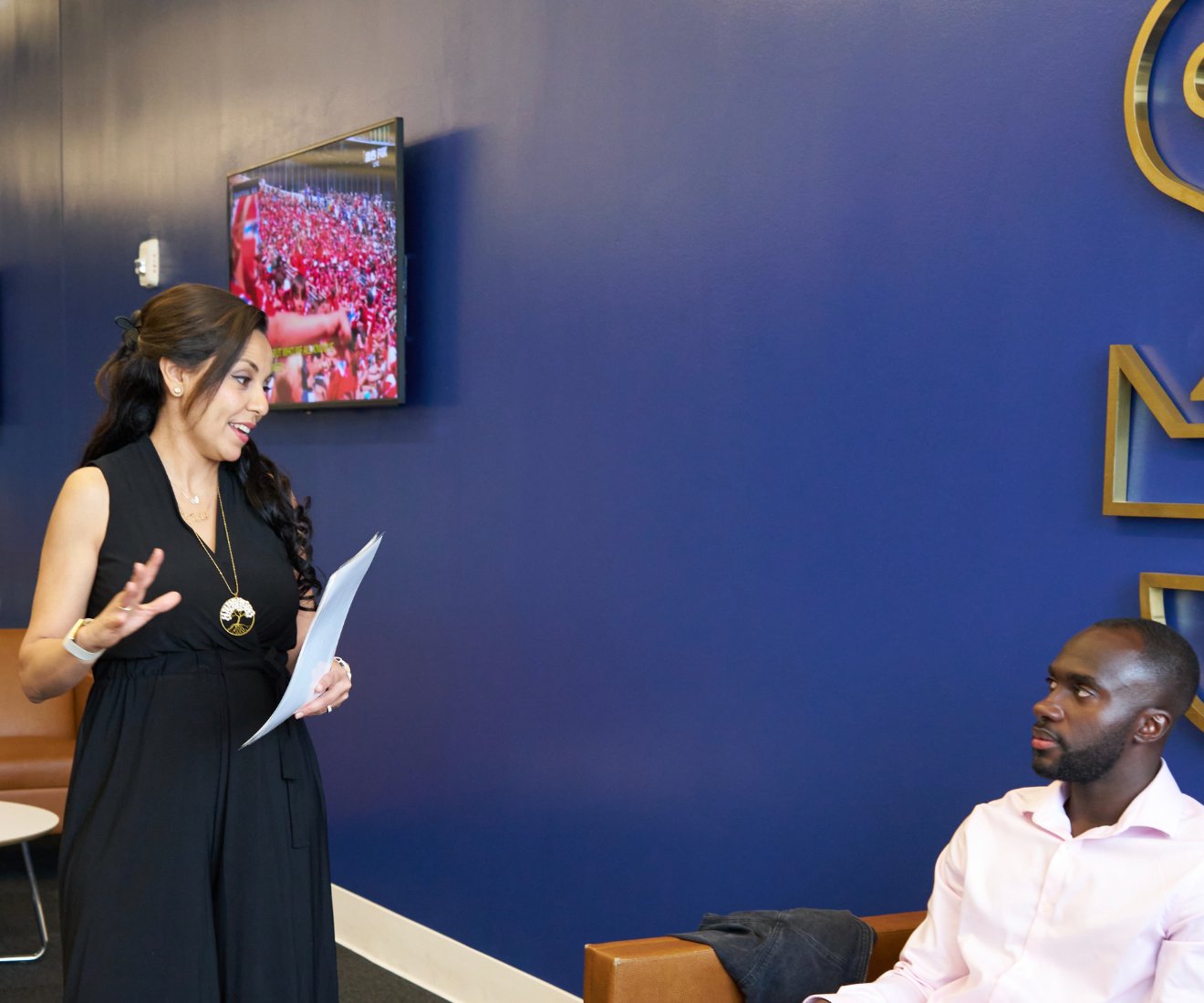Heba coaching a member one-to-one, both with worksheets