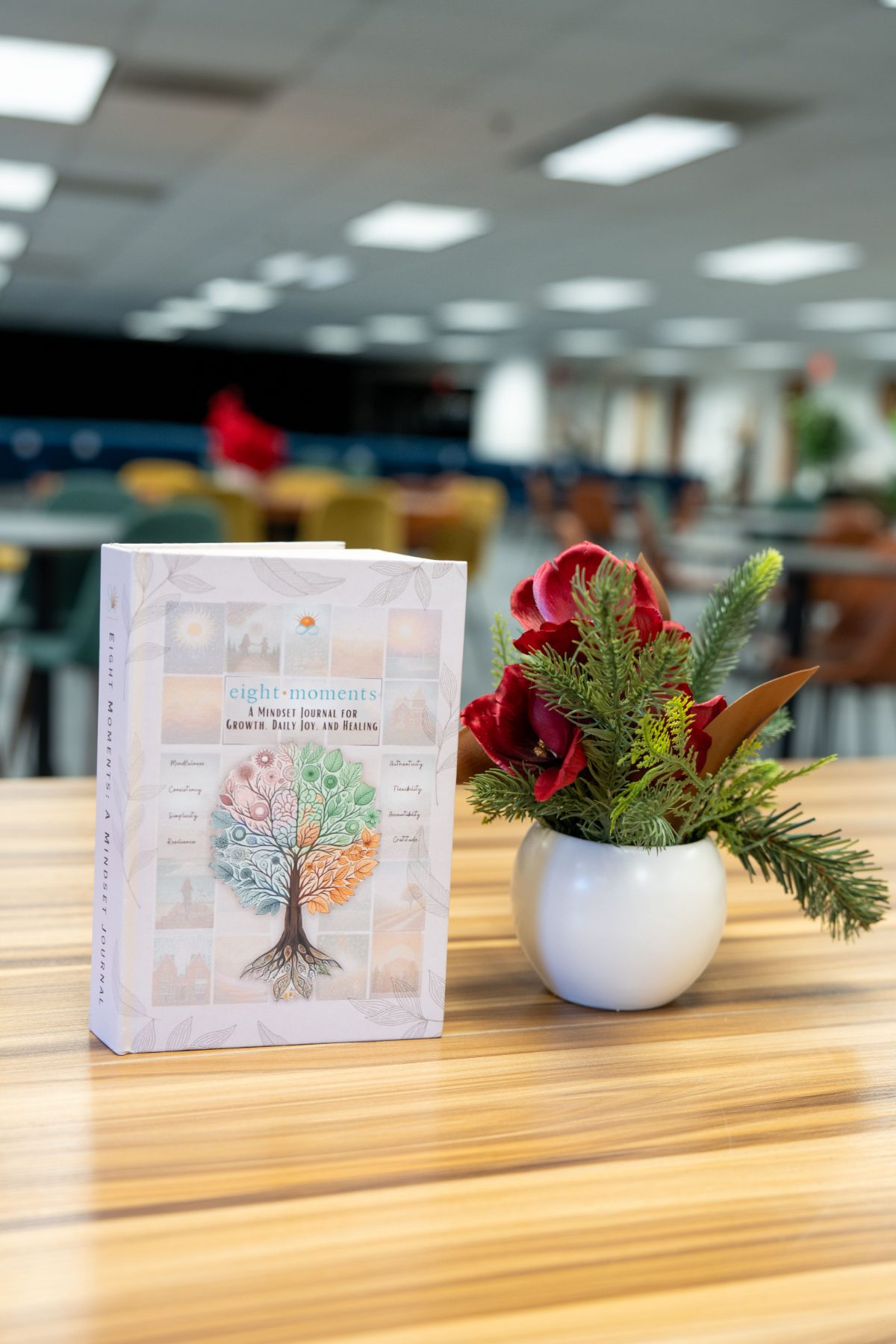 The journal standing on a table beside a small winter floral arrangement