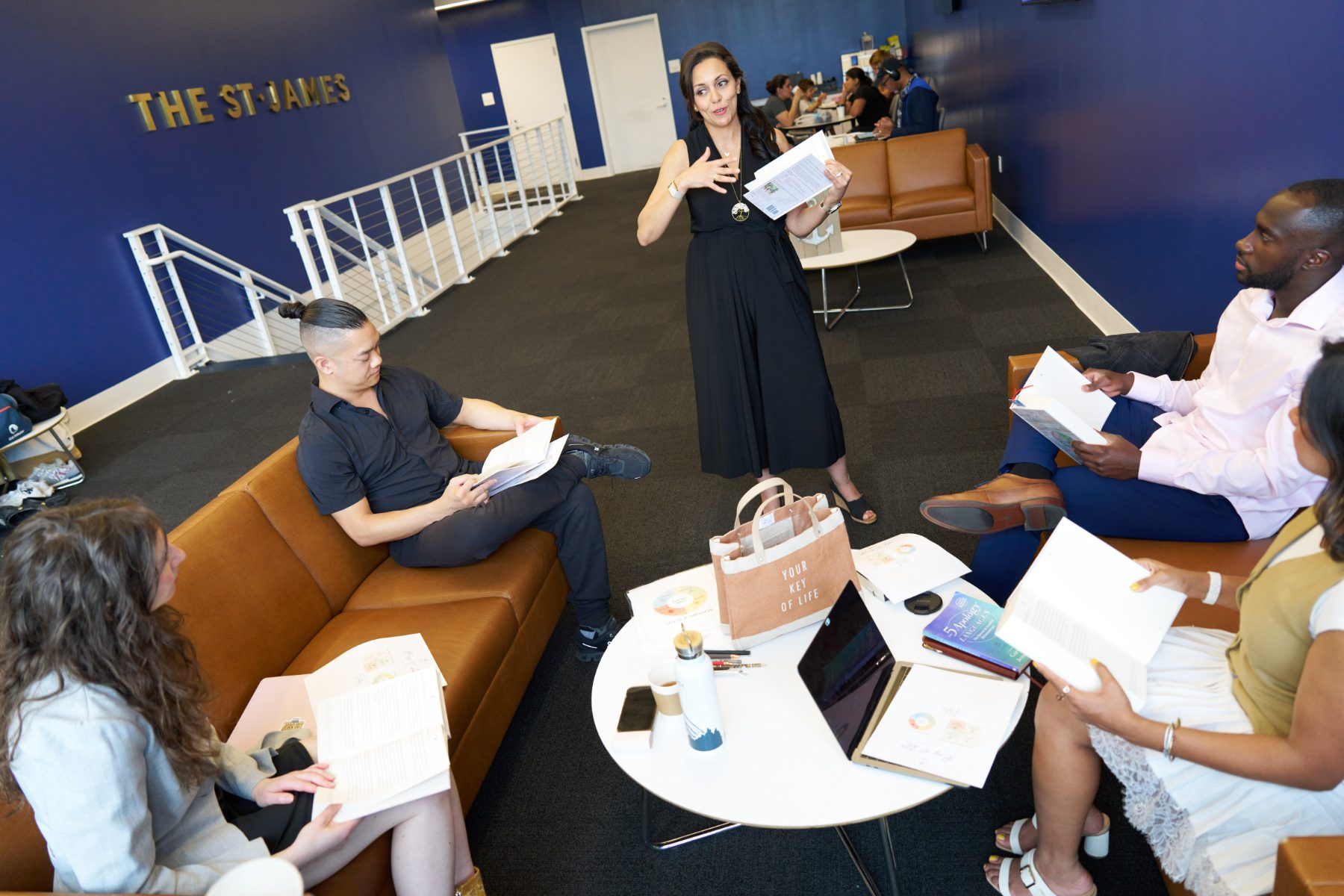Heba sharing the journal with a group gathered on couches