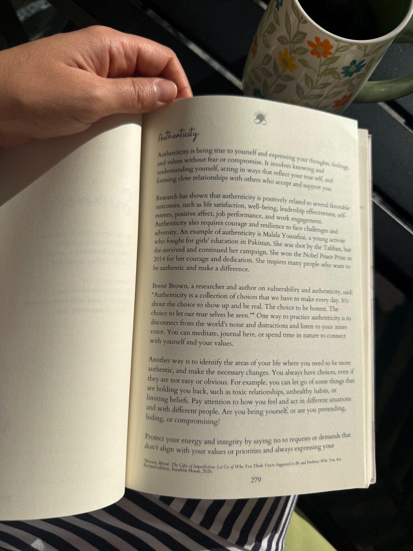 An open chapter read in the morning sun beside a floral mug
